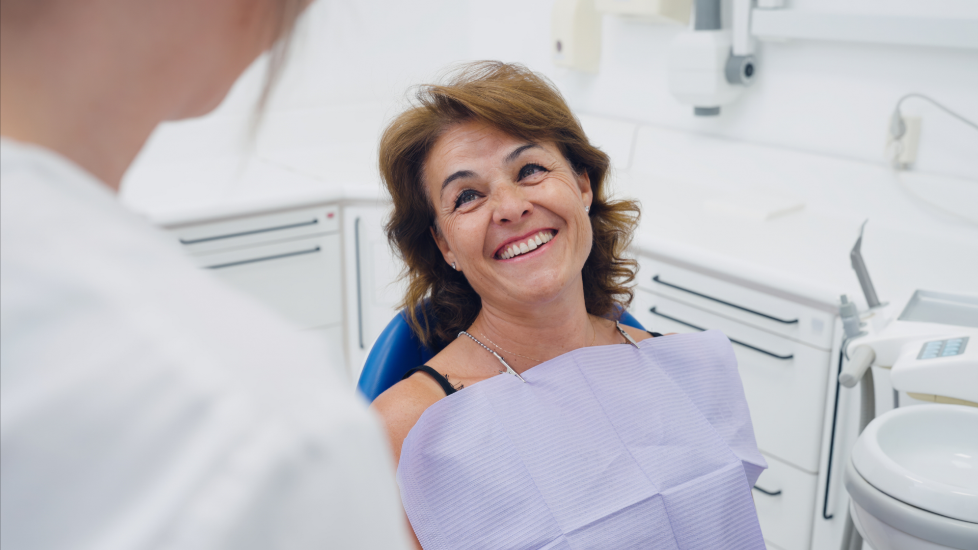 Donna sorridente in visita dal dentista per un controllo della salute orale