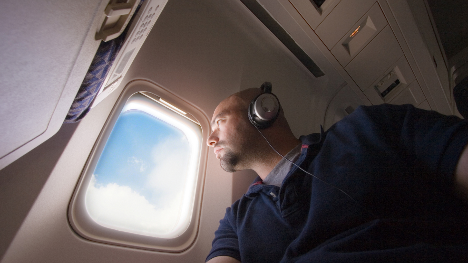 Barodontalgia: passeggero seduto al finestrino di un aereo durante il volo